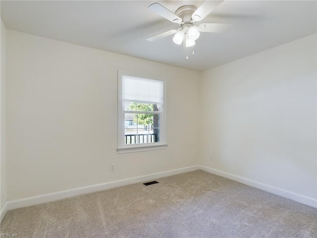 unfurnished room with carpet flooring, visible vents, and baseboards