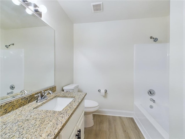 bathroom featuring visible vents, toilet, wood finished floors, tub / shower combination, and vanity