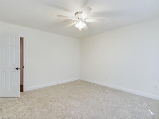 empty room with carpet flooring, baseboards, and a ceiling fan