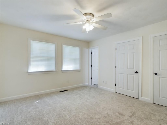 unfurnished bedroom featuring visible vents, a ceiling fan, baseboards, and carpet floors