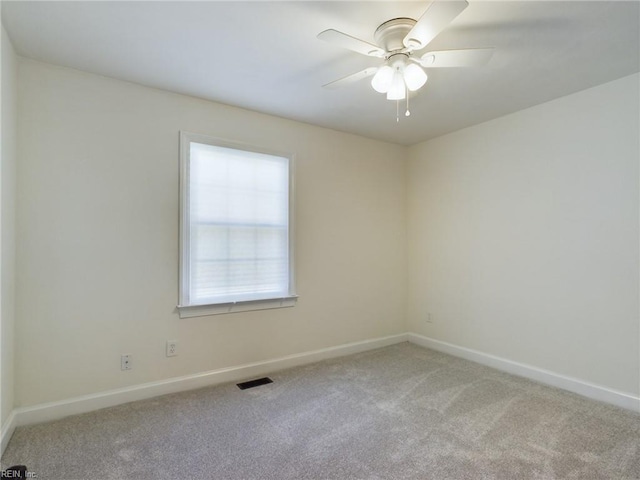 empty room with visible vents, baseboards, a ceiling fan, and carpet floors