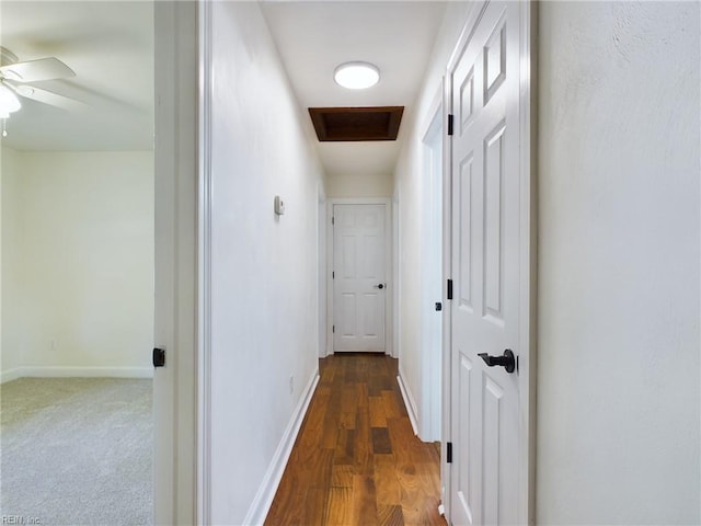 hall with baseboards, carpet floors, attic access, and wood finished floors