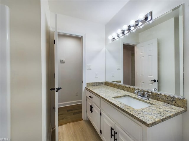 bathroom featuring vanity, wood finished floors, and baseboards