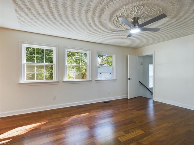 spare room with baseboards, plenty of natural light, and wood finished floors