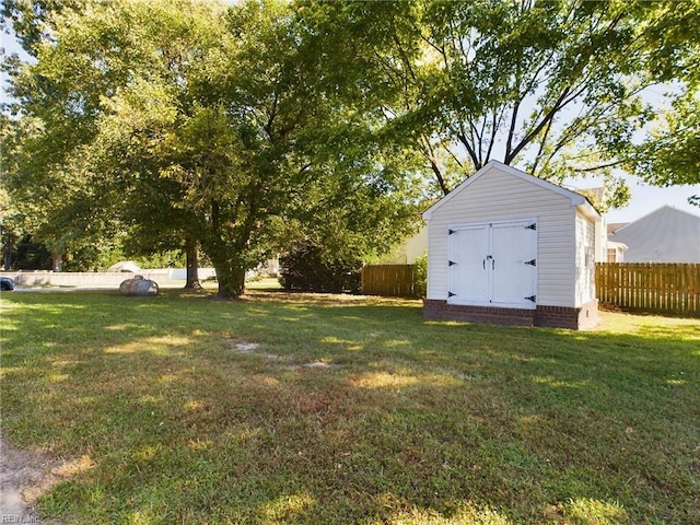 view of yard with an outdoor structure, a shed, and fence