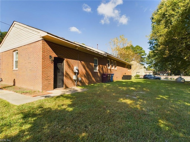 back of house featuring a yard and brick siding