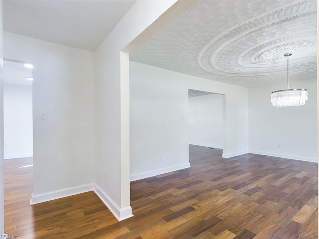 empty room with baseboards and dark wood-type flooring