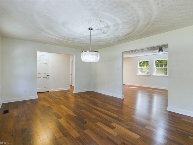 unfurnished room featuring dark wood-style floors, visible vents, and baseboards