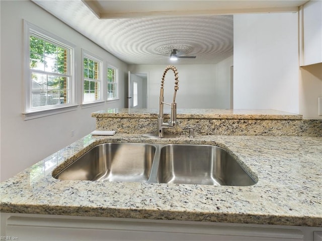 interior details featuring light stone countertops and a sink