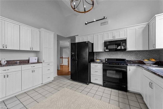 kitchen featuring visible vents, a notable chandelier, black appliances, high vaulted ceiling, and light tile patterned floors