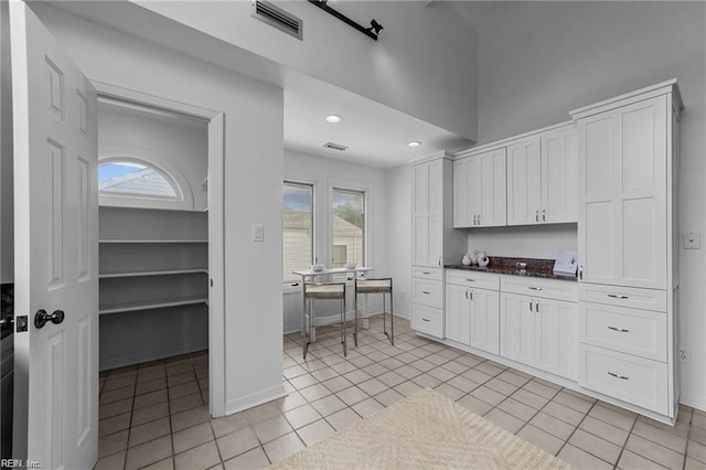 kitchen featuring white cabinets, light tile patterned flooring, recessed lighting, and visible vents