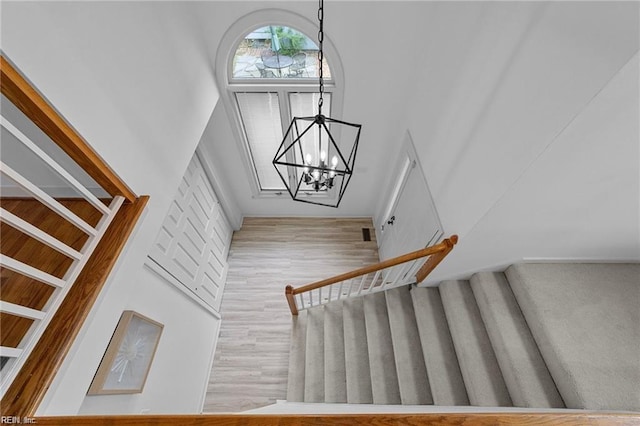 staircase featuring visible vents, a high ceiling, and an inviting chandelier