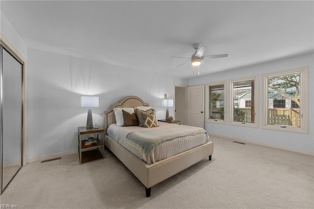 carpeted bedroom with visible vents, a ceiling fan, baseboards, and a closet