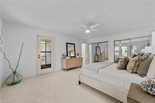 bedroom with a ceiling fan, baseboards, two closets, and light carpet