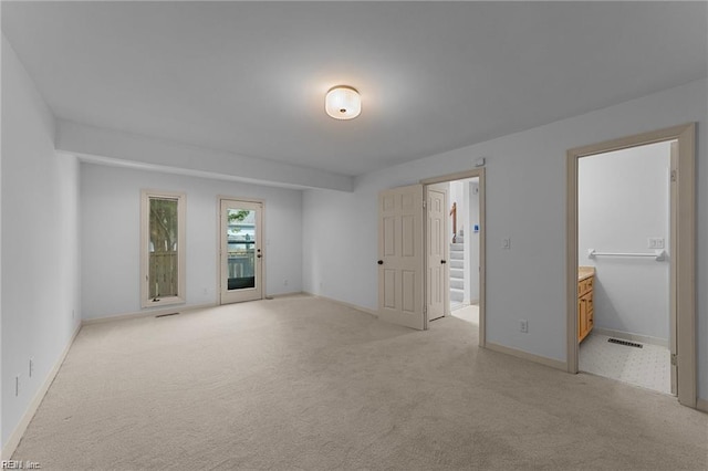 unfurnished bedroom with access to exterior, visible vents, light colored carpet, and baseboards