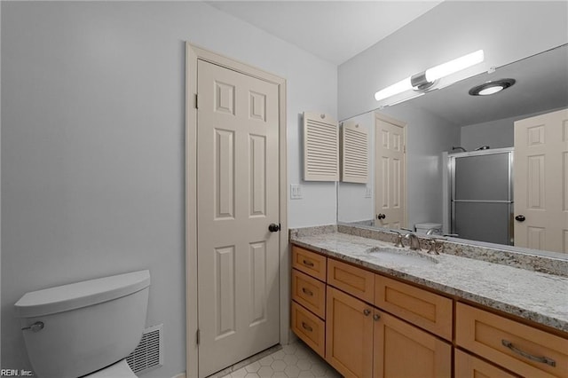 bathroom with visible vents, a stall shower, toilet, and vanity