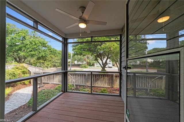 unfurnished sunroom featuring a ceiling fan