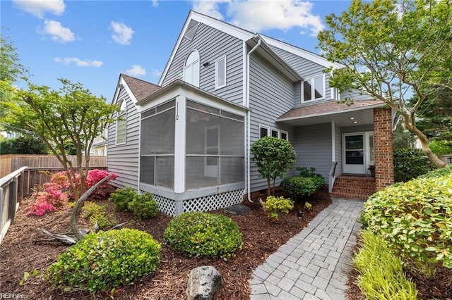 exterior space featuring a sunroom and fence