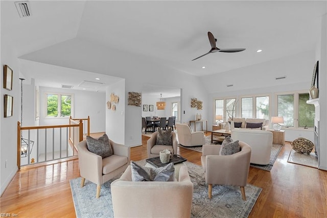 living area with a healthy amount of sunlight, light wood-style floors, lofted ceiling, and ceiling fan