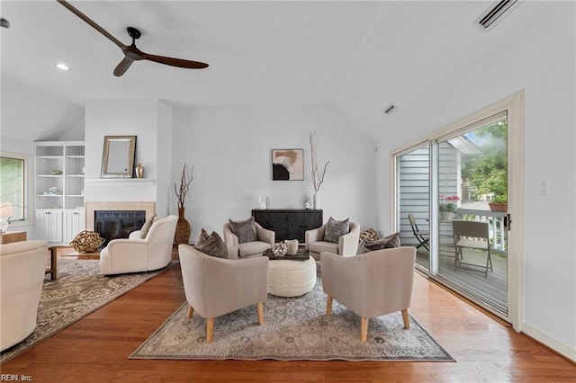 living area featuring wood finished floors, a ceiling fan, a wealth of natural light, and vaulted ceiling