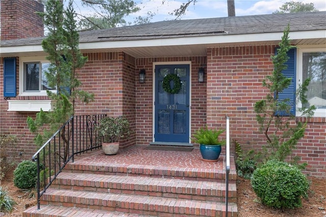 entrance to property featuring brick siding