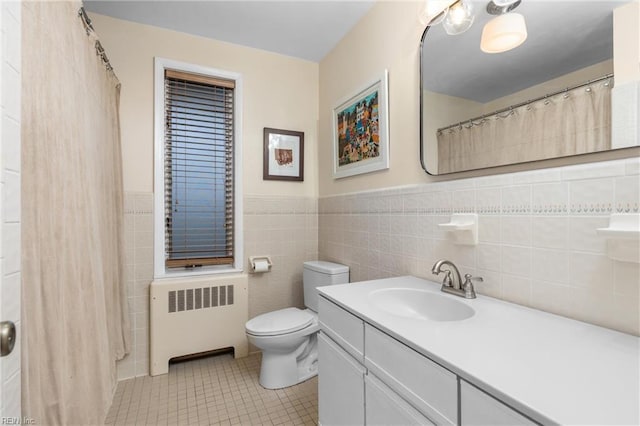 bathroom with tile patterned flooring, tile walls, toilet, radiator heating unit, and vanity