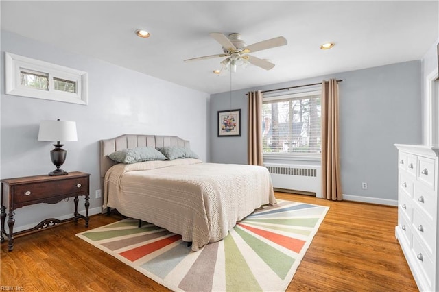 bedroom with radiator, baseboards, recessed lighting, light wood-style floors, and a ceiling fan