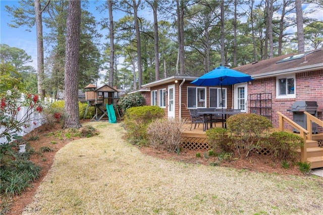 view of yard featuring a playground and a wooden deck