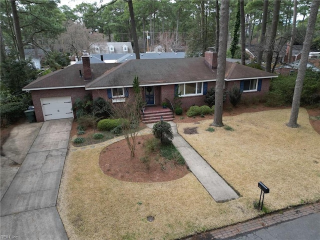 single story home with a front yard, an attached garage, a chimney, concrete driveway, and brick siding