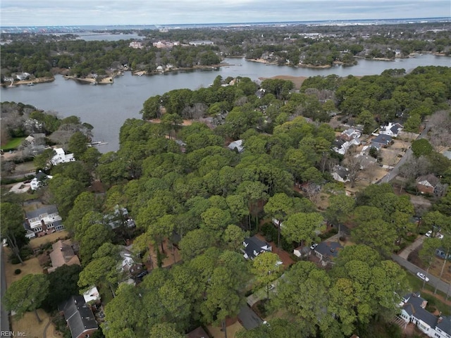 drone / aerial view with a wooded view and a water view