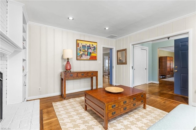 living room featuring crown molding, wood finished floors, and visible vents