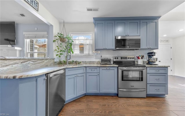 kitchen featuring a wealth of natural light, appliances with stainless steel finishes, dark wood-type flooring, and a sink