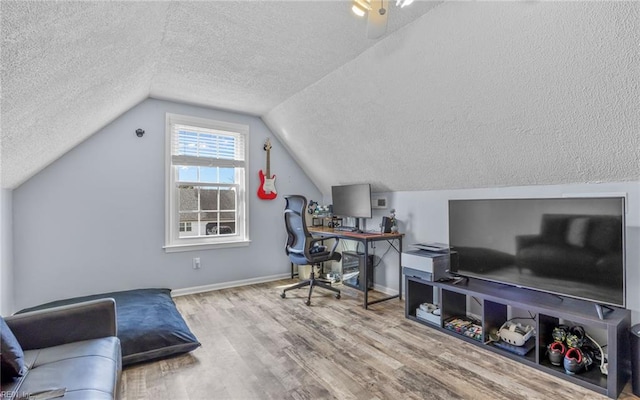 home office with lofted ceiling, wood finished floors, baseboards, and a textured ceiling