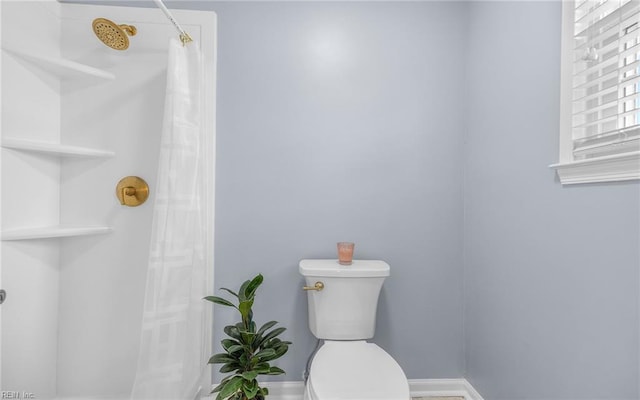 full bath featuring a shower with shower curtain, toilet, and baseboards