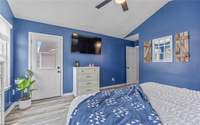 bedroom with a textured ceiling, wood finished floors, baseboards, ceiling fan, and vaulted ceiling