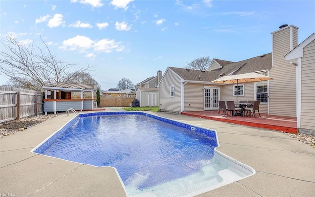 view of pool with an outbuilding, a fenced in pool, a fenced backyard, french doors, and a patio area