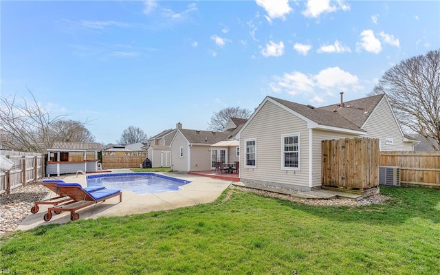 rear view of property featuring a fenced in pool, cooling unit, a yard, a fenced backyard, and a patio area