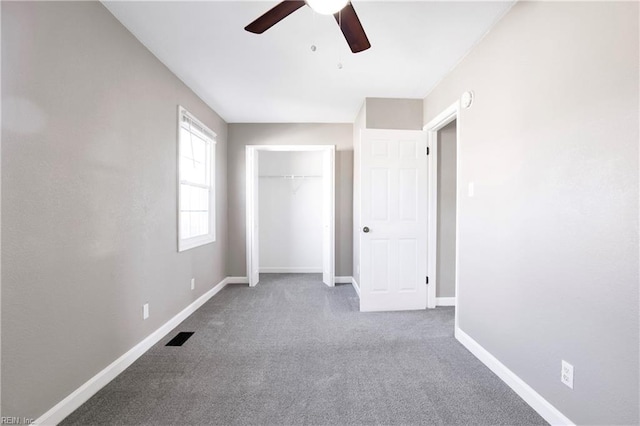 unfurnished bedroom featuring visible vents, a closet, carpet flooring, baseboards, and ceiling fan