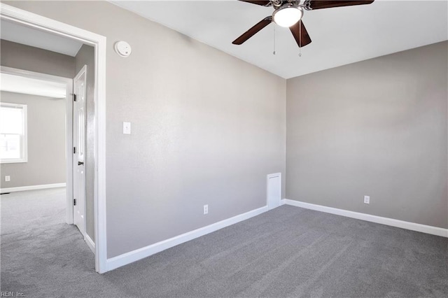 empty room with ceiling fan, baseboards, and carpet