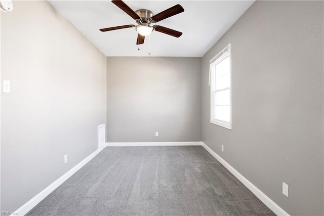 carpeted empty room featuring a ceiling fan and baseboards