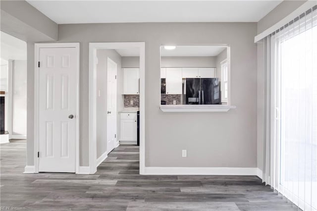 unfurnished living room featuring baseboards and wood finished floors