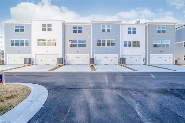 exterior space with an attached garage and central AC unit