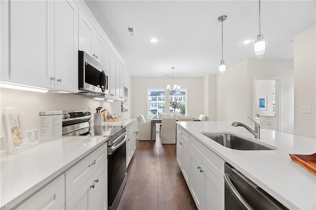 kitchen with visible vents, a sink, stainless steel appliances, white cabinets, and light countertops