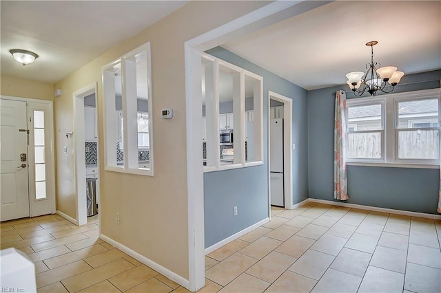 foyer entrance featuring baseboards and an inviting chandelier