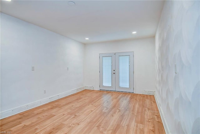 spare room with recessed lighting, french doors, baseboards, and light wood-style flooring