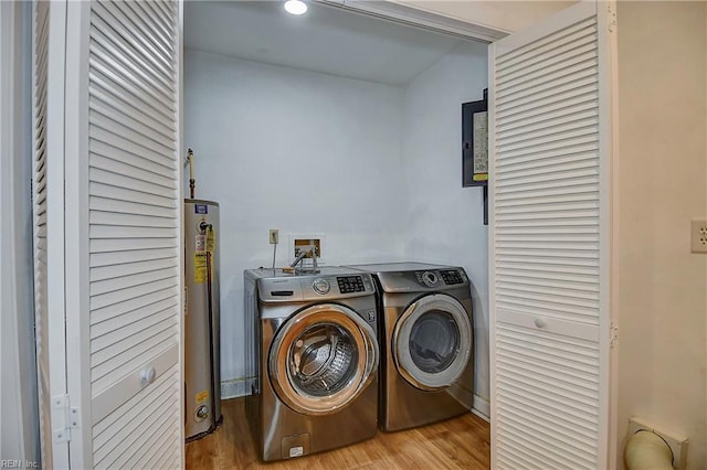 clothes washing area featuring gas water heater, independent washer and dryer, wood finished floors, and laundry area