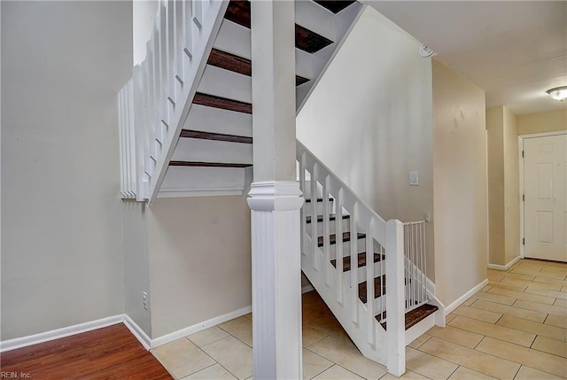 staircase with baseboards and wood finished floors