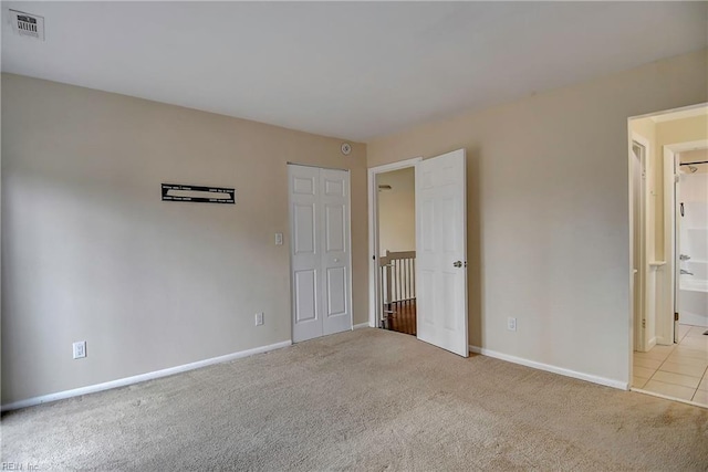 unfurnished bedroom featuring baseboards, visible vents, and carpet floors