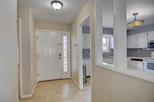 entryway with light tile patterned flooring and baseboards