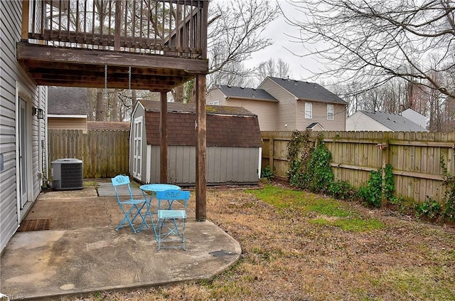 view of yard featuring a shed, a fenced backyard, central AC, an outdoor structure, and a patio area